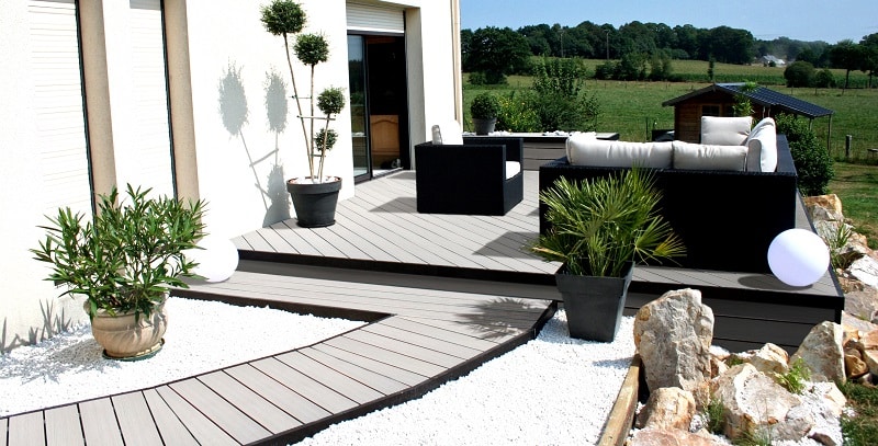 allée de jardin et terrasse en lames composites gris clair posées en diagonale