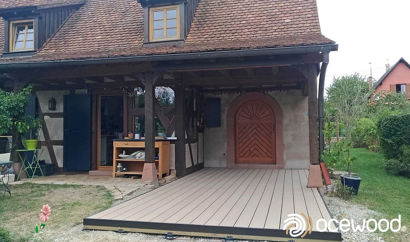 Petite terrasse comme entrée de maison en lames composites effet bois. 
