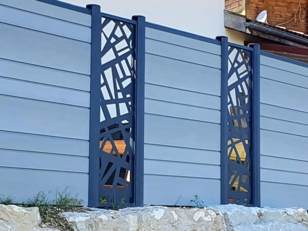 clôture composite gris clair basalte. lames décoratives géométriques. poteaux gris foncé.