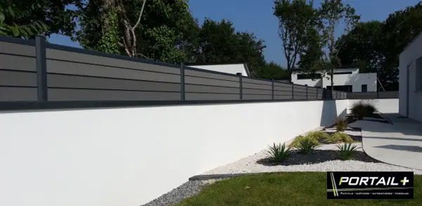 Jolie petite palissade en composite gris anthracite sur muret blanc pour maison contemporaine